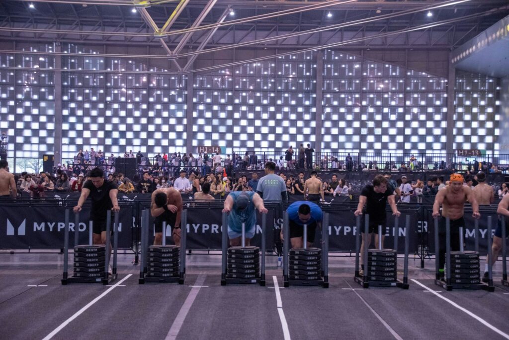 Atletas empujando trineos lastrados en una competición Hyrox