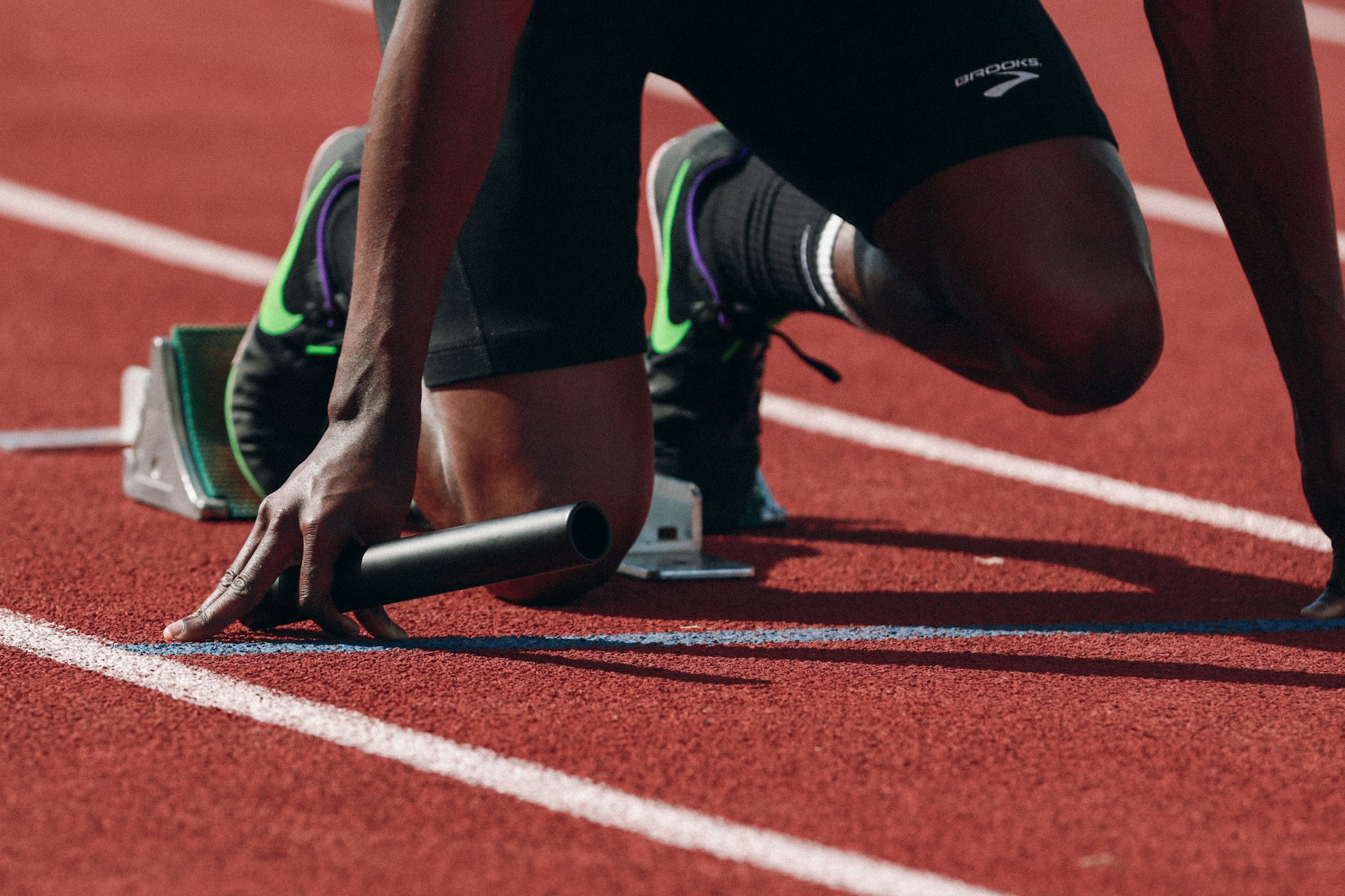 Atleta en posicion de salida en una pista, entrenamiento de resistencia