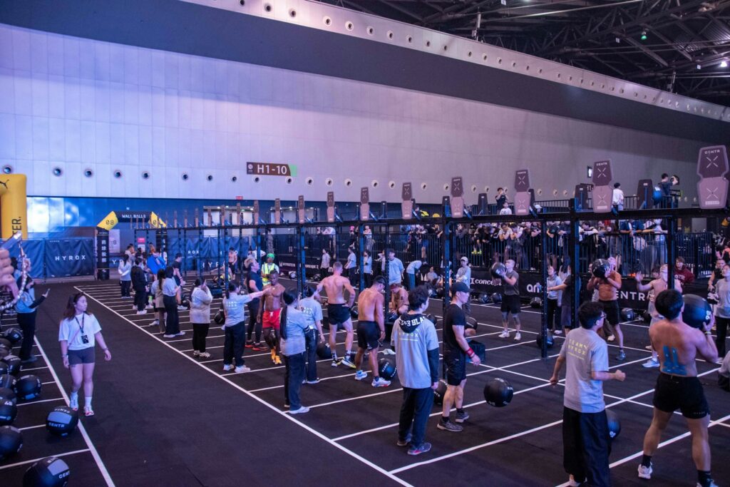 Grupo de atletas entrenando en las distintas estaciones de una prueba Hyrox