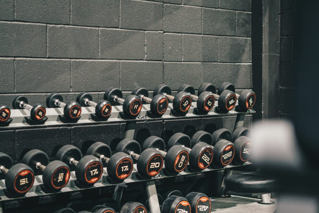 Kettlebells rojas y negras ordenadas en el suelo de un box de CrossFit