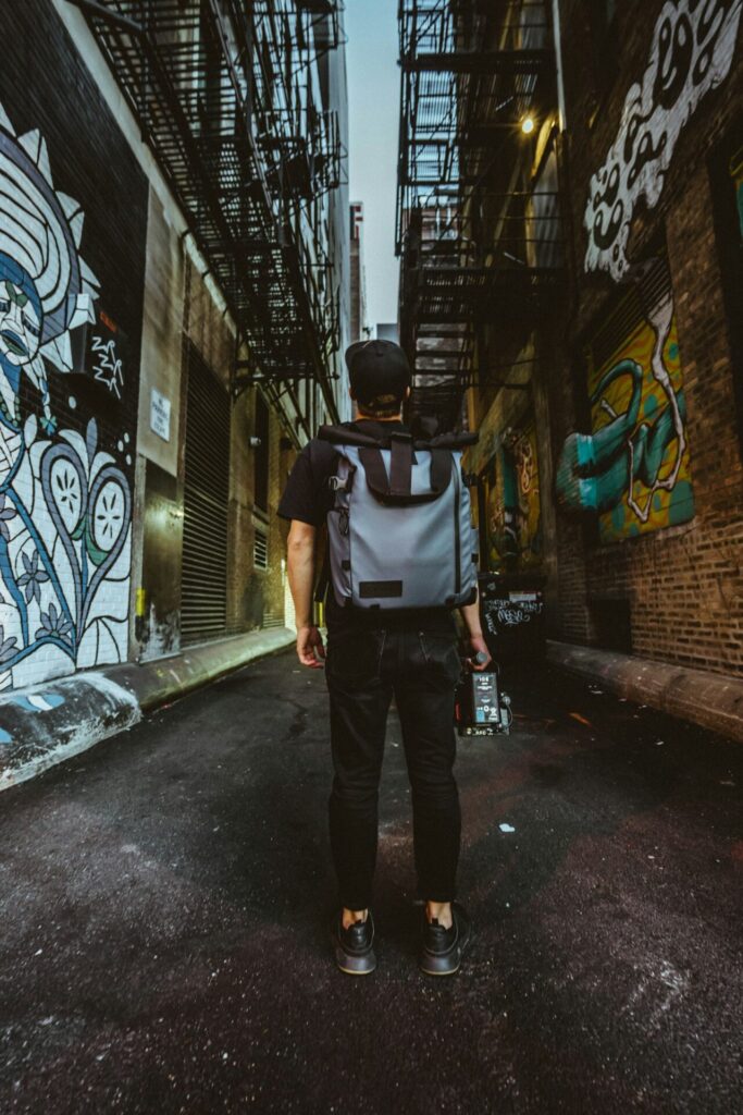 Viajero con mochila caminando por la ciudad en busca de un box donde hacer drop-in