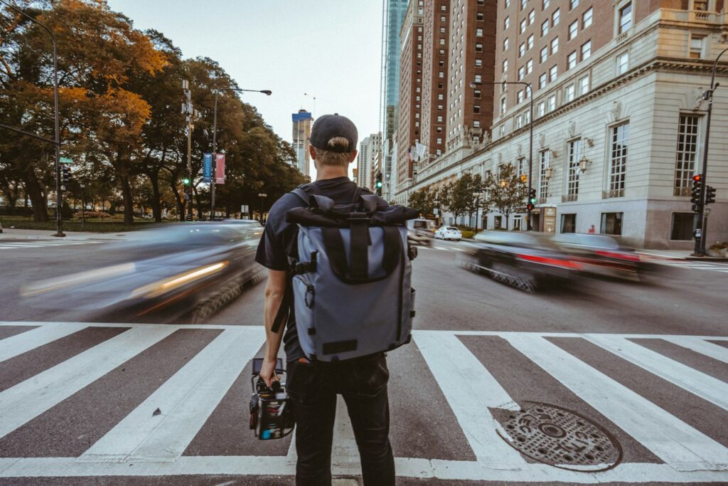 Viajero con mochila caminando por la ciudad, listo para entrenar en un box de drop-in